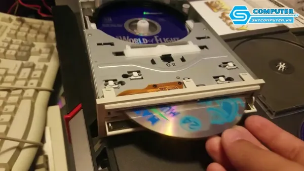 Một chiếc đĩa CD đang được đưa vào ổ đĩa của máy tính xách tay