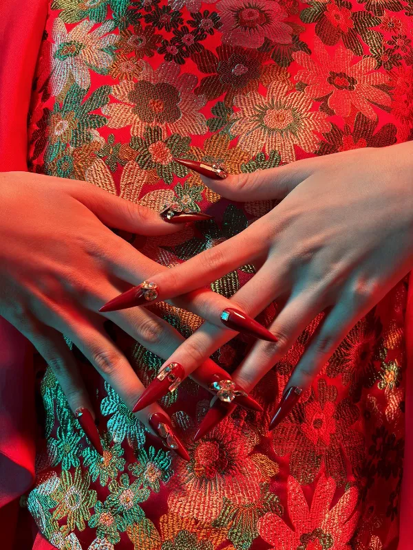 Ảnh chụp một người đang tạo dáng bên cành đào ngày Tết bằng chế độ hiệu suất cao của iPhone 15