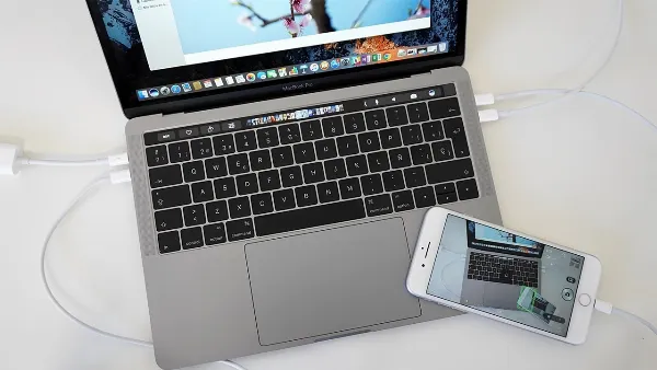 Hai thiết bị iPhone và MacBook được đặt cạnh nhau, hiển thị màn hình cài đặt Wi-Fi