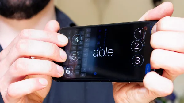 Hình ảnh minh họa một người khiếm thị đang sử dụng iPhone với màn hình Braille, thể hiện sự tiện lợi và hỗ trợ mà thiết bị mang lại cho người dùng