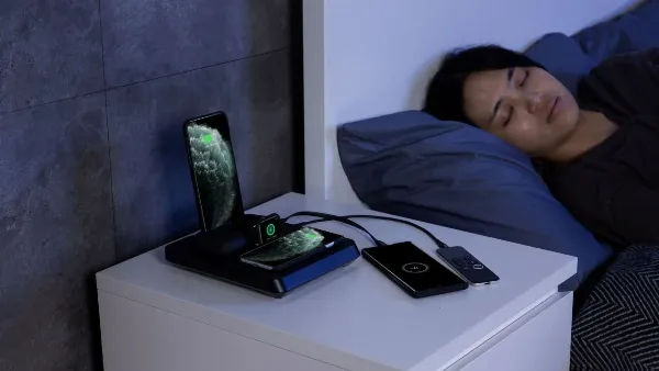 Hình ảnh một chiếc iPhone 12 đang được cắm sạc cạnh ổ điện vào ban đêm