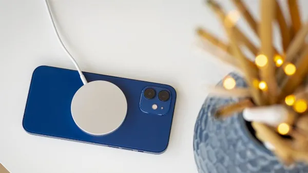 Một chiếc iPhone 12 màu xanh dương đang được cắm sạc pin