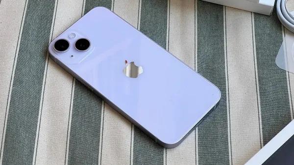 Một chiếc iPhone 14 màu xanh dương, mặt lưng với cụm camera kép, đặt trong hộp màu trắng