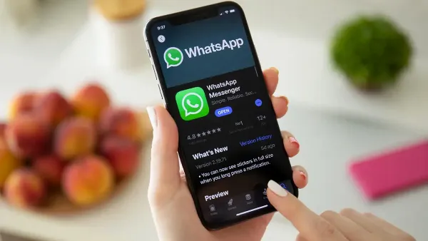 Một điện thoại thông minh đang hiển thị ứng dụng WhatsApp, với màn hình yêu cầu nhập mã xác minh gồm 6 chữ số.
