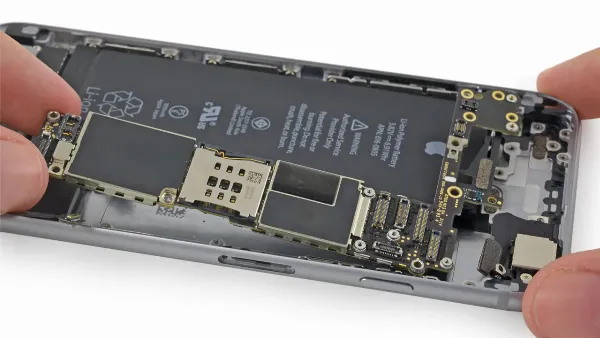 Một kỹ thuật viên đang cầm bo mạch chủ của iPhone, minh họa cho việc kiểm tra phần cứng là bước quan trọng để xác định nguyên nhân lỗi