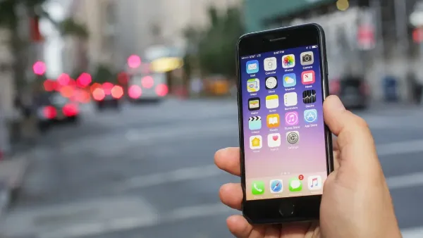 Có nên mua iPhone bị mất vân tay không? Đây là lý do để bạn đưa ra quyết định để mua hàng đúng đắn 9 Một người đang cầm chiếc iPhone màu đen, phía sau là nhiều chiếc iPhone khác, nền màu xám