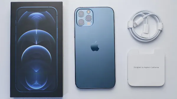 Một người đang cầm trên tay chiếc iPhone màu đen, màn hình hiển thị giao diện cài đặt mạng di động